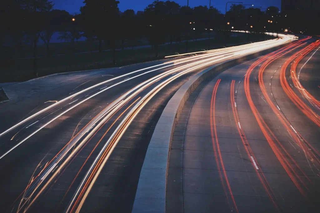 Light trails sweeping around a curved highway at night, like data streaming into a page