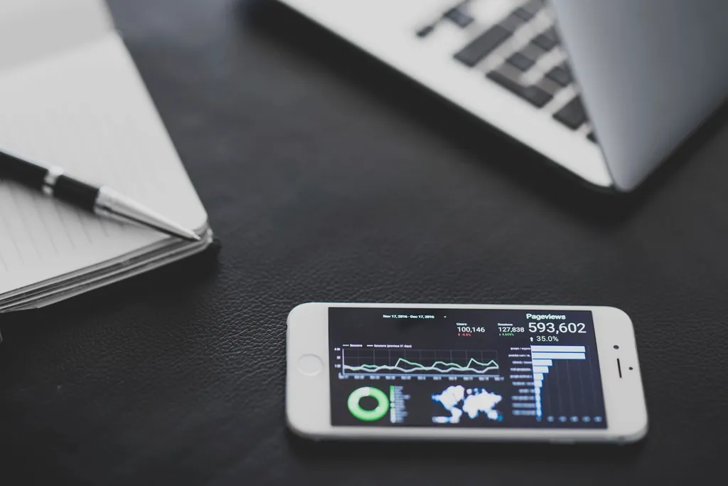 Smartphone analytics dashboard on a desk, used to measure each migrated route