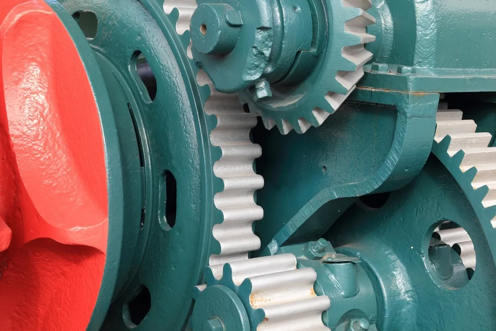 Teal and red gears meshing in a transmission, like a framework and commerce layer working together