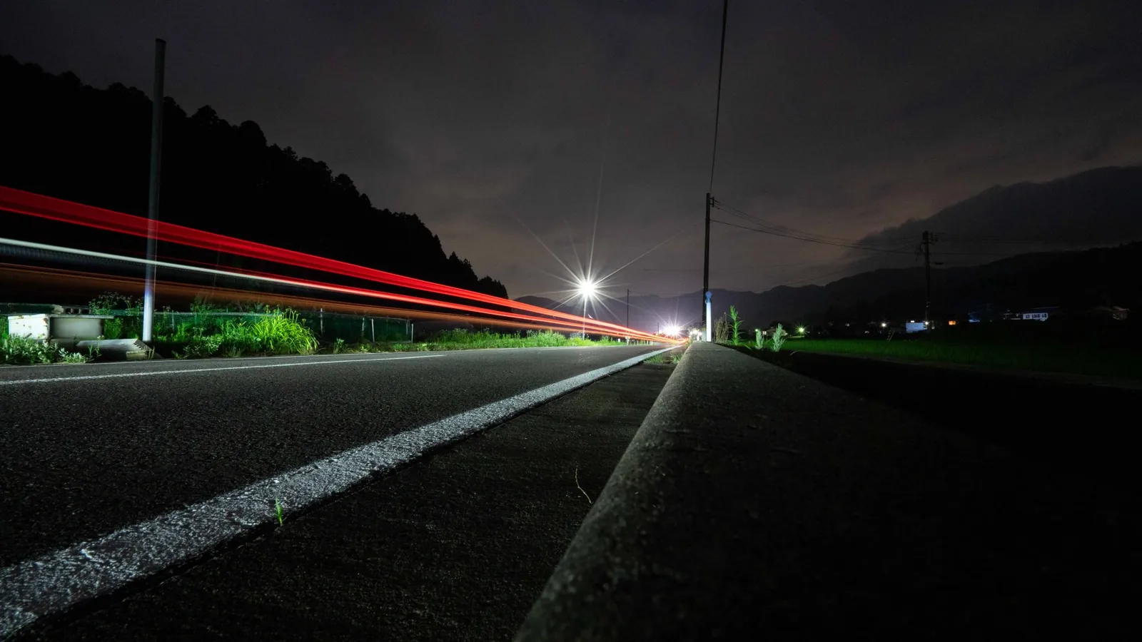 Red light trail along a road at night, with urgent updates moving first