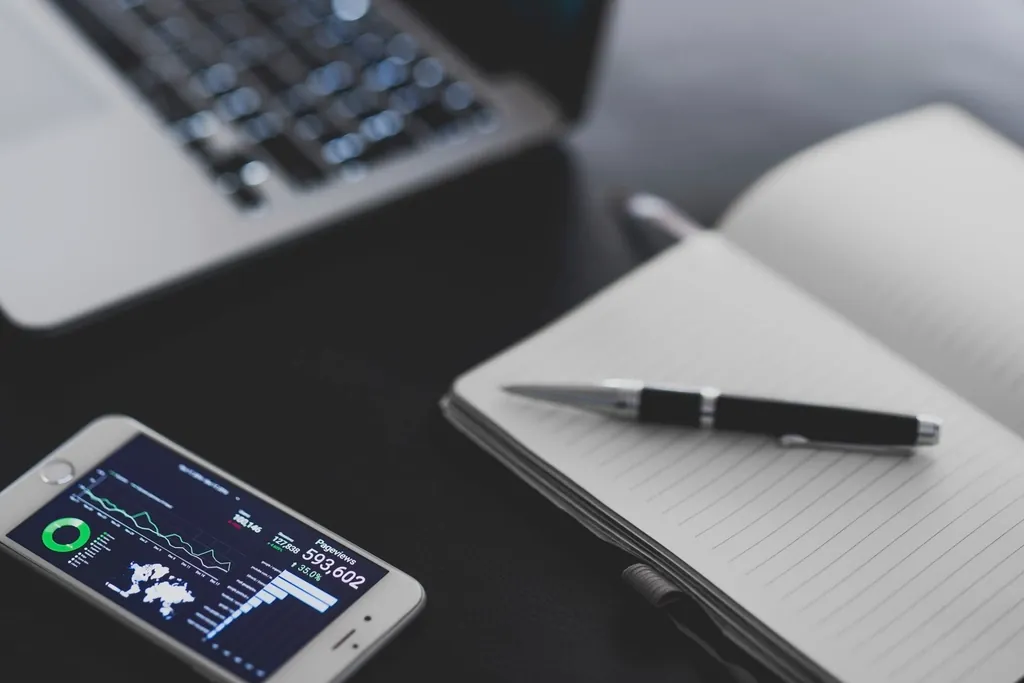 Smartphone analytics app beside a notebook and laptop, showing real visitor field data
