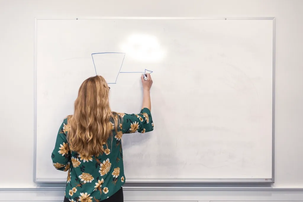Person seen from behind drawing an architecture diagram on a whiteboard