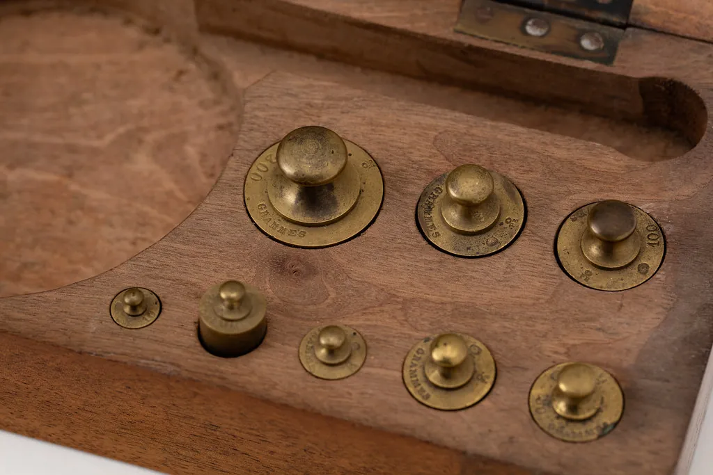 Brass weights fitted into a wooden case, like an extension bundle with a size limit