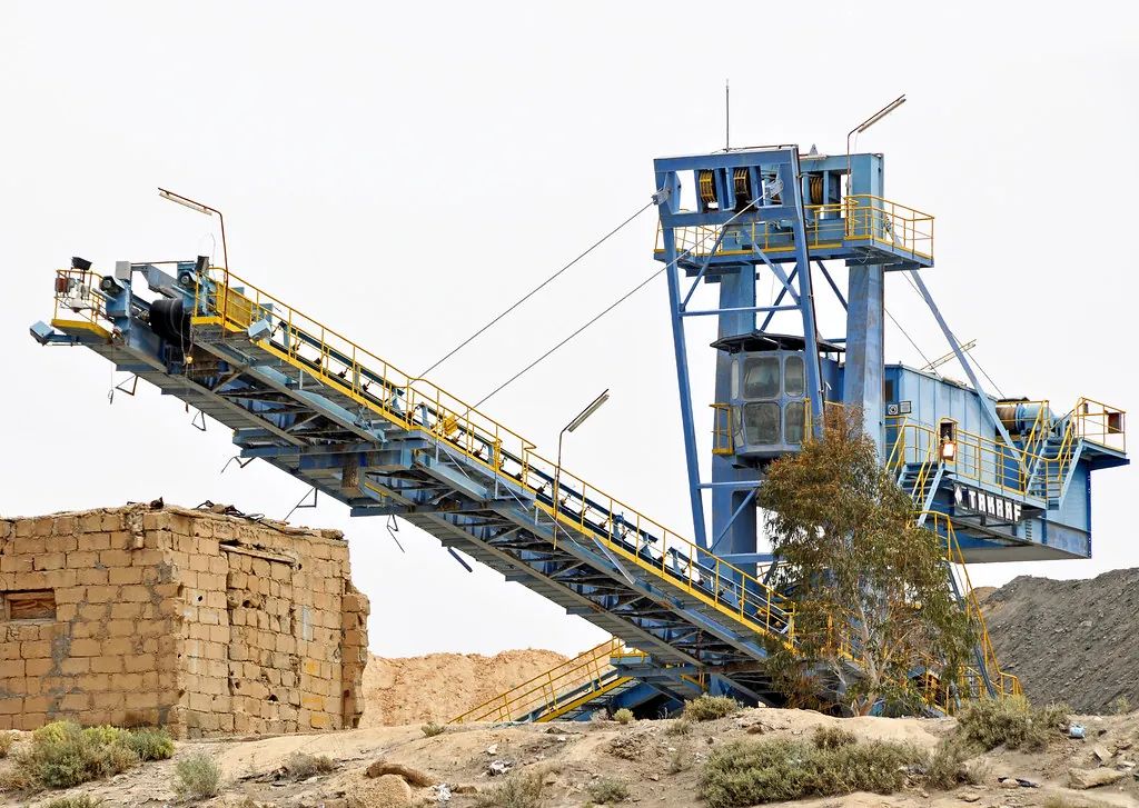 Large industrial conveyor rising from a quarry, moving everything through one system