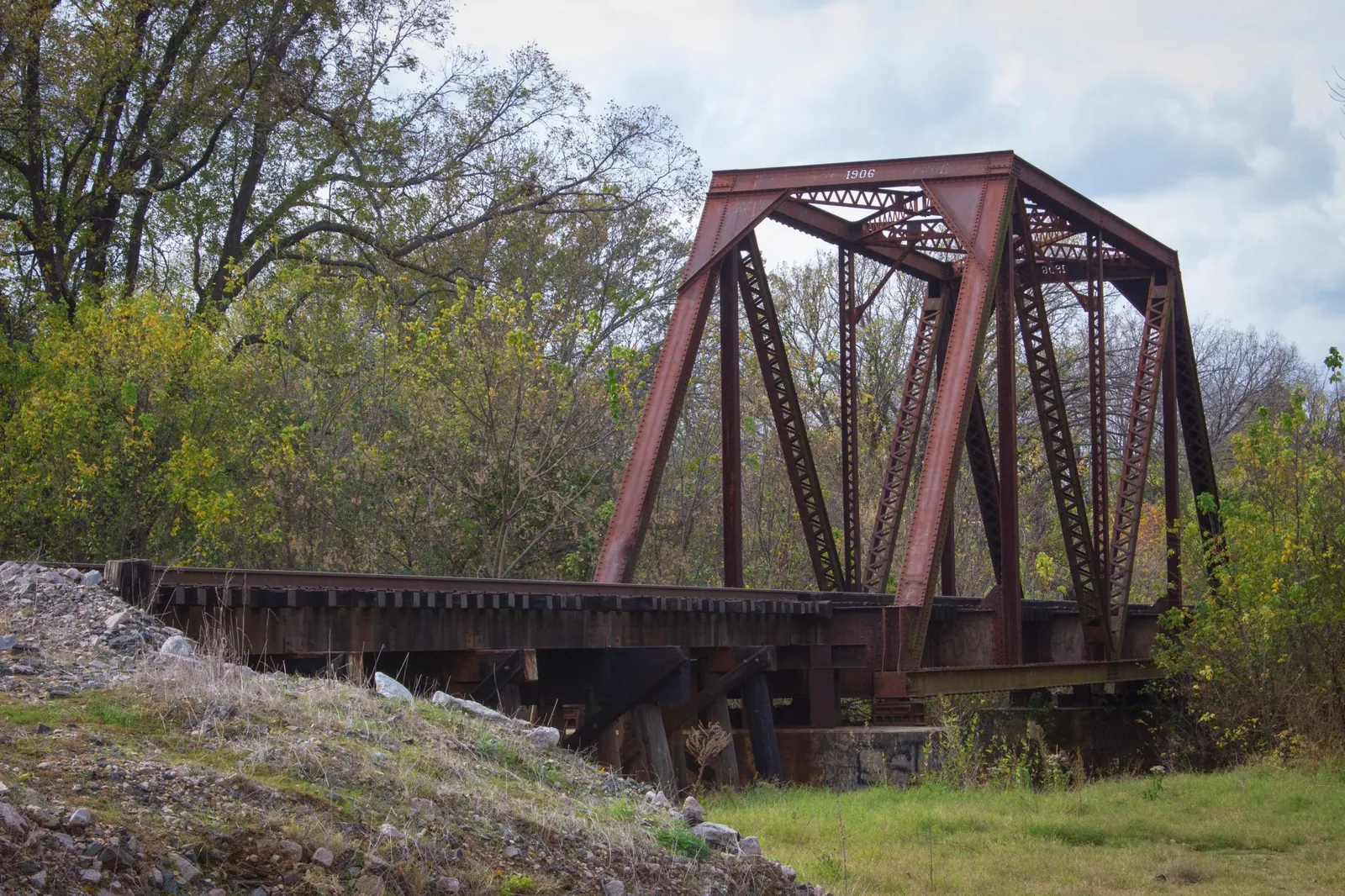 Old red railroad truss bridge, a steady crossing while a build migration happens