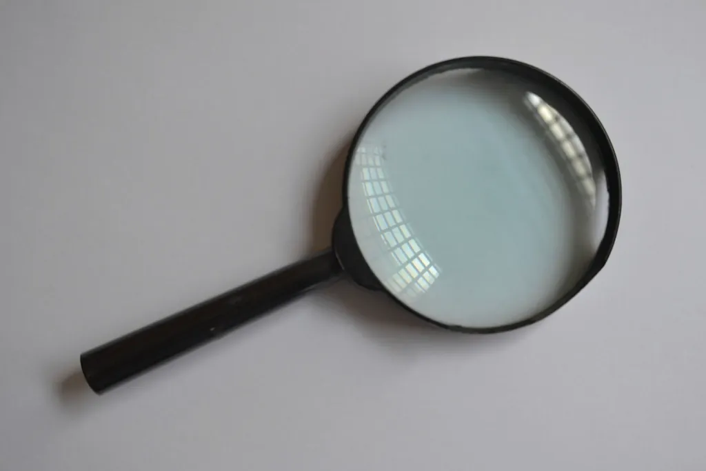 Magnifying glass on a grey background, a reminder that every generated change needs review