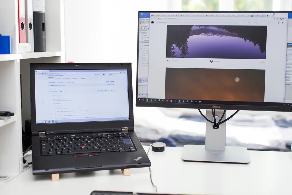 Laptop beside a second monitor on an office desk, for comparing before and after screenshots