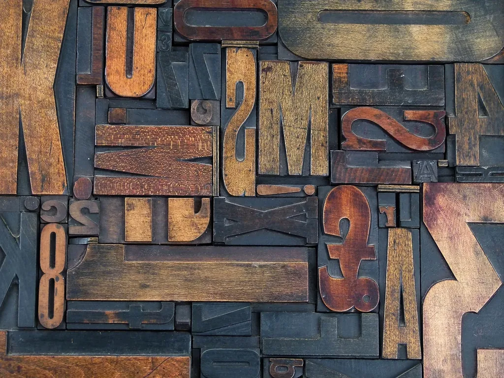 Jumble of wooden letter blocks in uneven sizes, like cards that size rows on their own