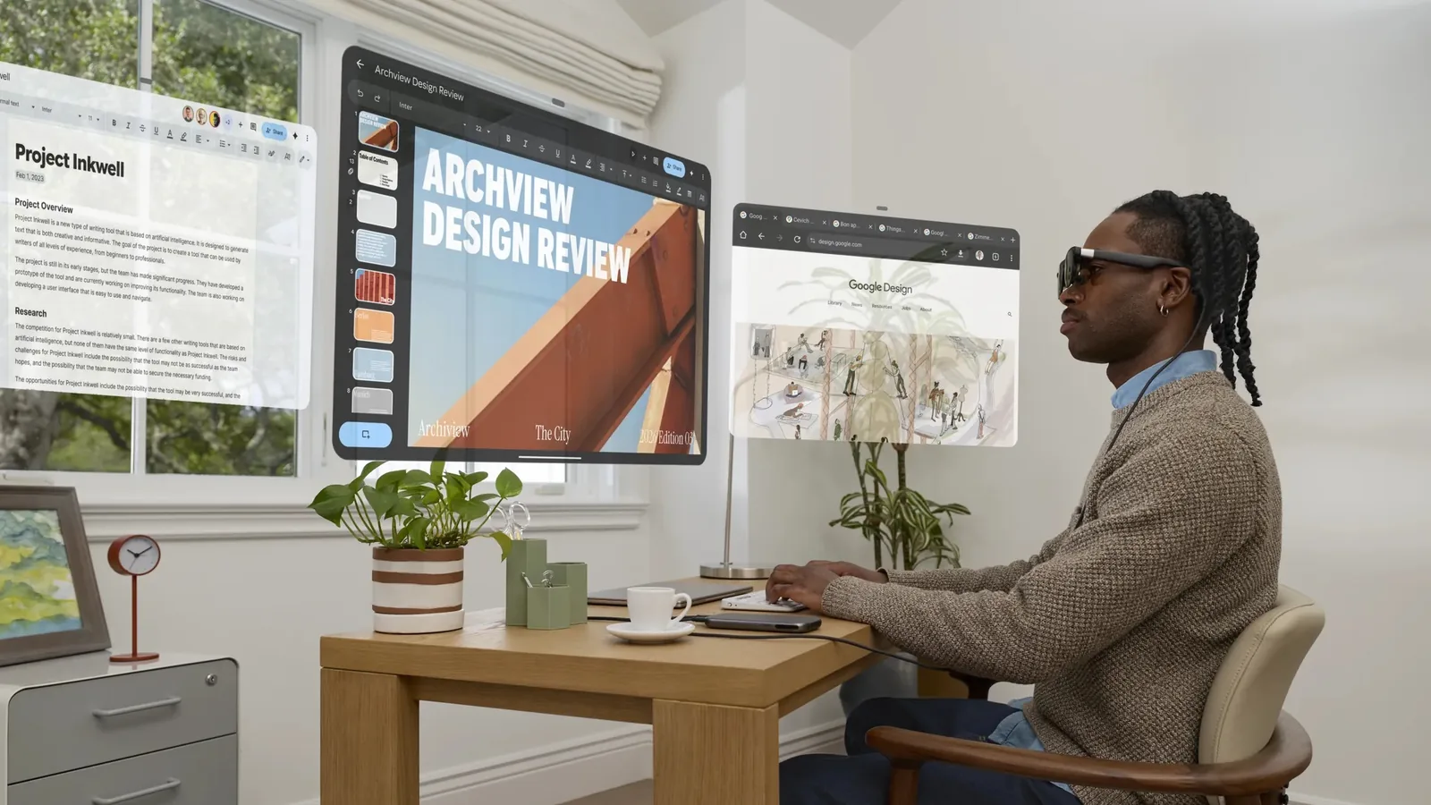 Person using XREAL AURA Android XR glasses with several app windows at a desk